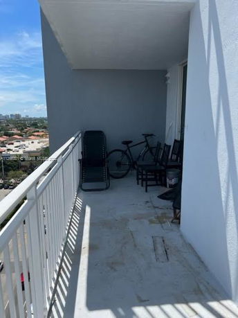 Outdoor balcony with a view of surrounding buildings and horizon.