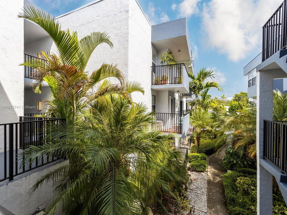 View of apartment balconies with surrounding lush greenery.
