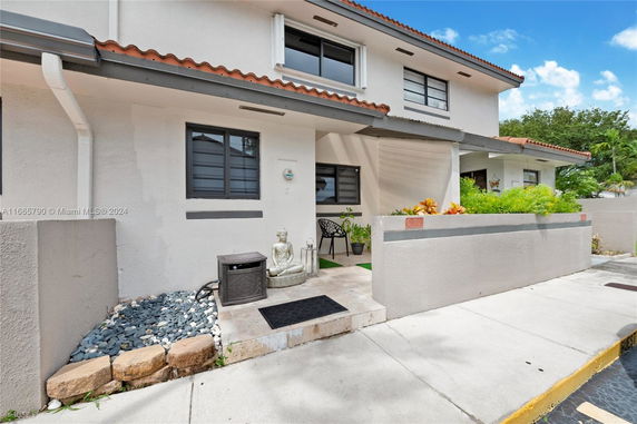 Front view of a two-story house with a small patio and decorative elements.