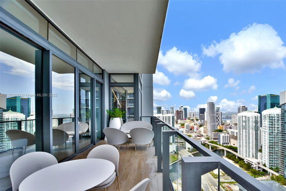 Balcony view from a modern building overlooking the cityscape with high-rise buildings.