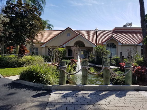 Front view of a house with a tile roof and well-maintained landscape.