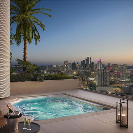 Rooftop with a jacuzzi overlooking a city skyline at dusk.
