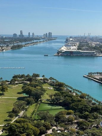 Wide angle view of a waterfront area with parks and buildings in the distance.
