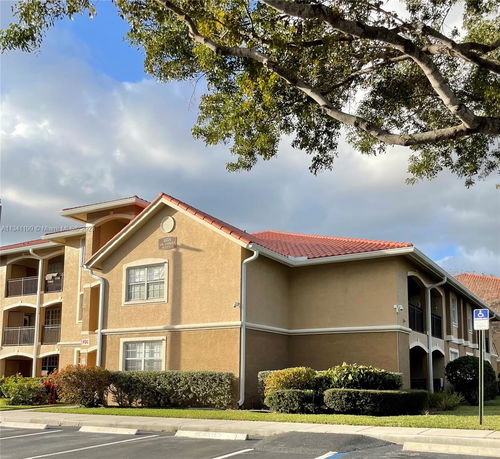 Front view of a two-story apartment building with red-tiled roof and balconies.
