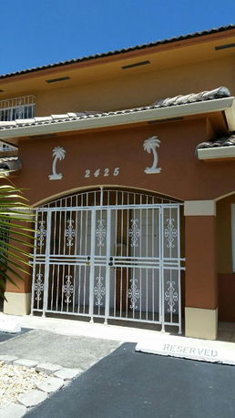 Front view of a two-story house with decorative metal gates.