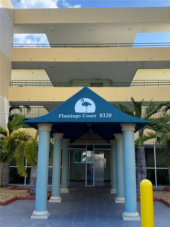 Front view of a building with a blue canopy labeled 'Flamingo Court 8320'.
