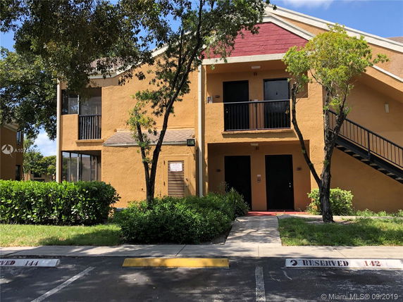 Front view of a two-story residential building with exterior stairs.