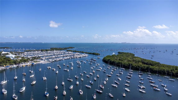 Panoramic view of a marina with numerous sailboats anchored in the water.