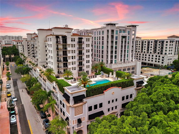 Aerial view of modern multi-story residential buildings with a rooftop swimming pool.