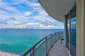 Panoramic view from a building balcony overlooking the ocean.