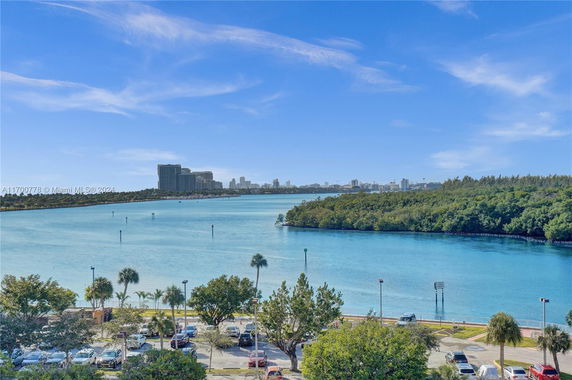 View of water with city buildings and trees in the distance.