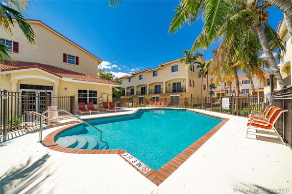 Outdoor swimming pool area with surrounding residential buildings.