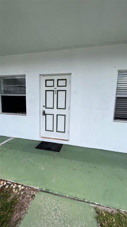 Front view of a house entrance with a door and windows.