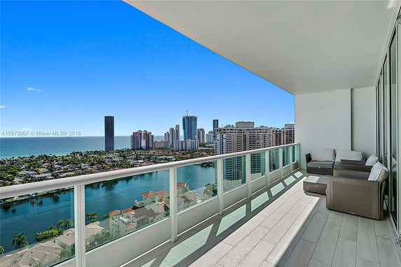 Balcony view overlooking coastal cityscape and ocean.