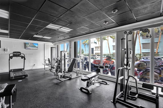 Indoor gym area with exercise equipment and large windows.