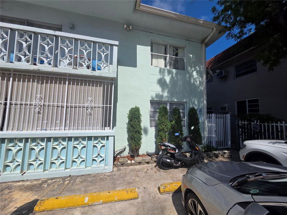 Front view of a two-story building with decorative railings.