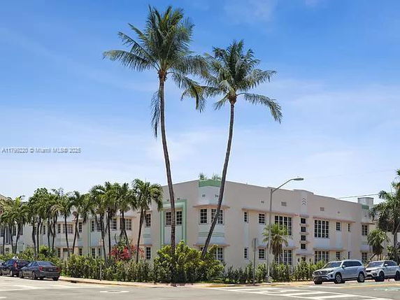 Front view of a multi-story building with palm trees.