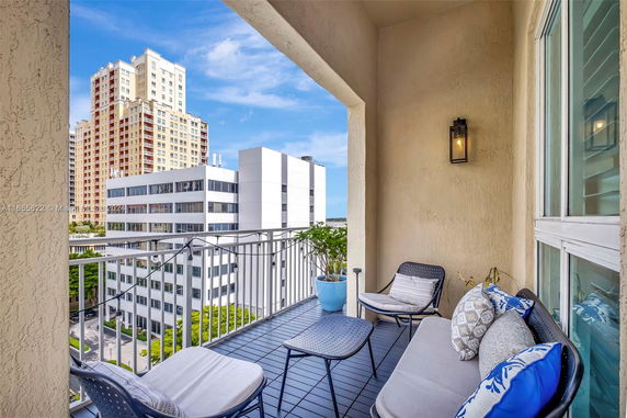 Balcony view of city buildings with outdoor seating.
