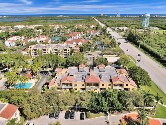 Aerial view of a residential area with apartment buildings, roads, and a swimming pool.