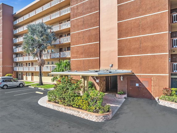 Front view of a multi-story apartment building with balconies.