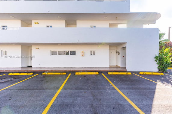 Exterior view of a building with designated parking spaces in front.