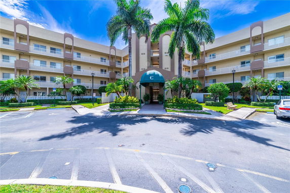 Front view of a multi-story residential building with balconies and a central entrance.