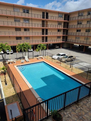 Outdoor swimming pool with surrounding multi-story building.