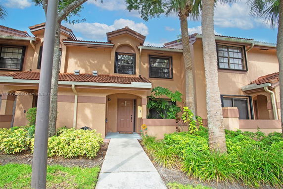 Front view of a two-story house with a brown roof and large windows.