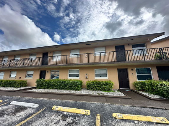 Front view of a two-story apartment building with upper and lower entry doors.