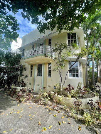 Front view of a two-story house with a small balcony and landscaped entrance.