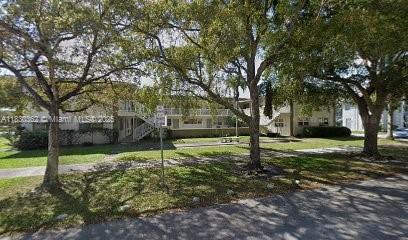 Front view of a two-story residential building with trees in front.