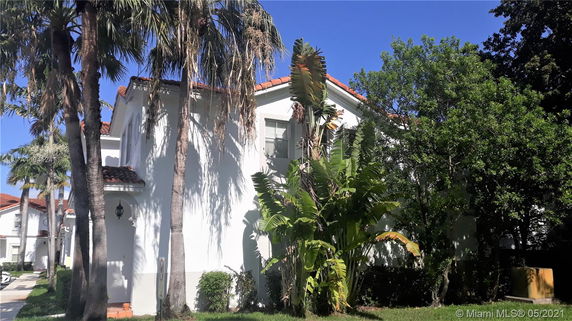 Front view of a two-story house with white walls and a red-tiled roof.
