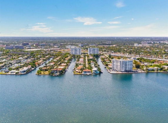 Panoramic view of a coastal area with residential and high-rise buildings surrounded by water.