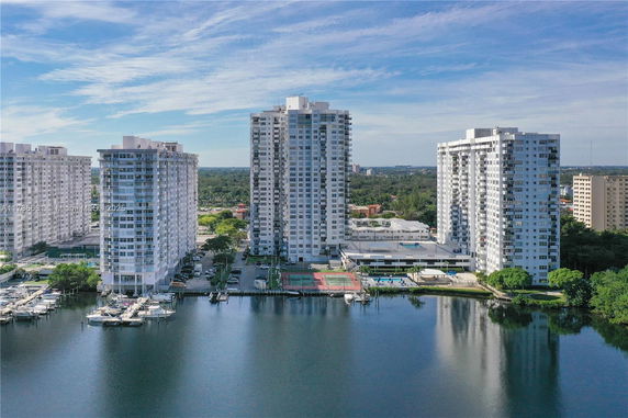 Exterior view of multiple high-rise buildings near a waterfront with docks.