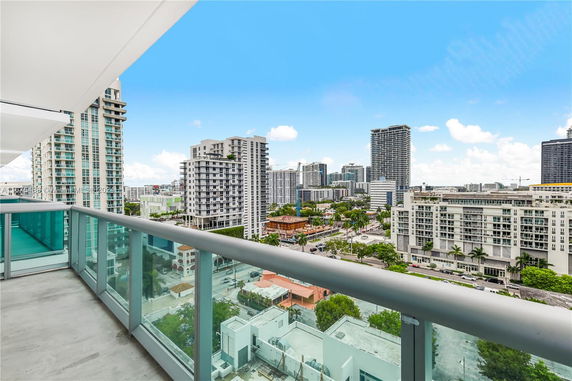 Panoramic view of cityscape from a balcony with tall buildings.