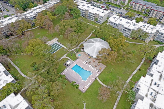 Aerial view of a residential complex with a central swimming pool and surrounding buildings.