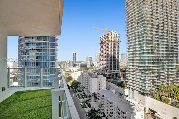 Panoramic view from a high-rise building, showing several multi-story buildings and a cityscape with a construction crane.