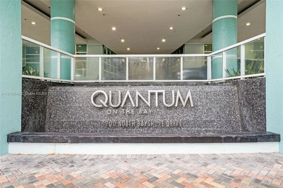 Front view of a building entrance featuring a sign for Quantum on the Bay.