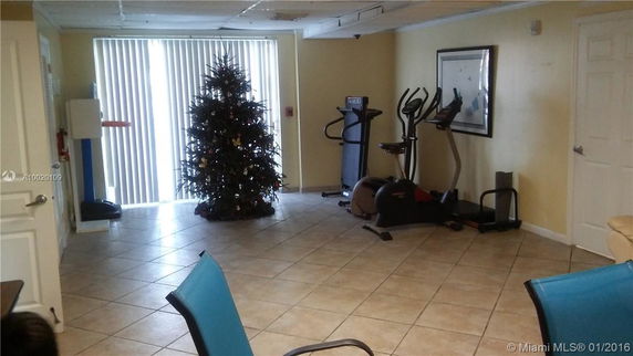 Indoor room with gym equipment and a decorated Christmas tree.