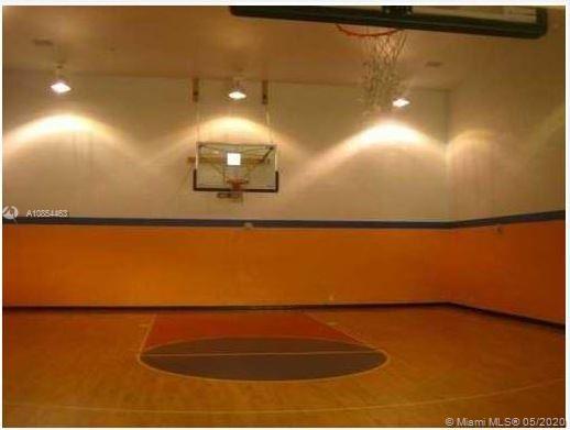 Indoor basketball court with two hoops and hardwood flooring.