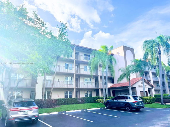 Front view of a multi-story building with adjacent parking area.