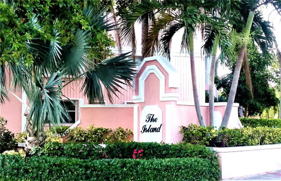 Front view of a building with a pink facade and decorative entrance sign.