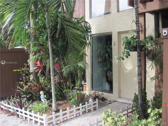 Front view of a two-story building with a small garden and glass entrance.