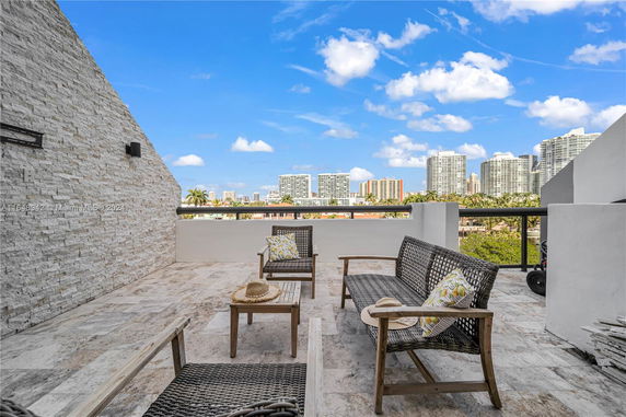 Rooftop terrace with seating and view of city skyline.