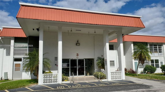 Front view of a building with a red pitched roof and white facade.