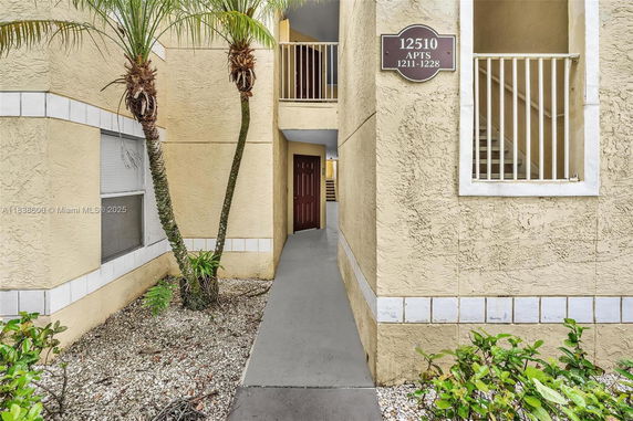 Entrance view of an apartment building with a door and walkway.