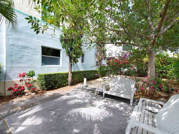 Outdoor area with benches and plants next to a building exterior.