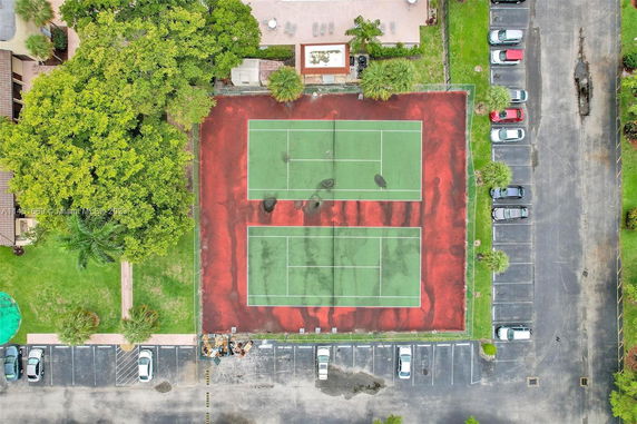Aerial view of a tennis court with adjacent parking area.