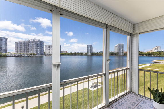 Overlooking a body of water with high-rise buildings in the background from a balcony.
