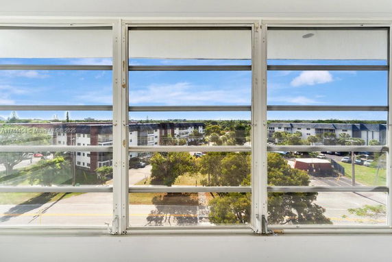 View from a window showing a complex of buildings and greenery.